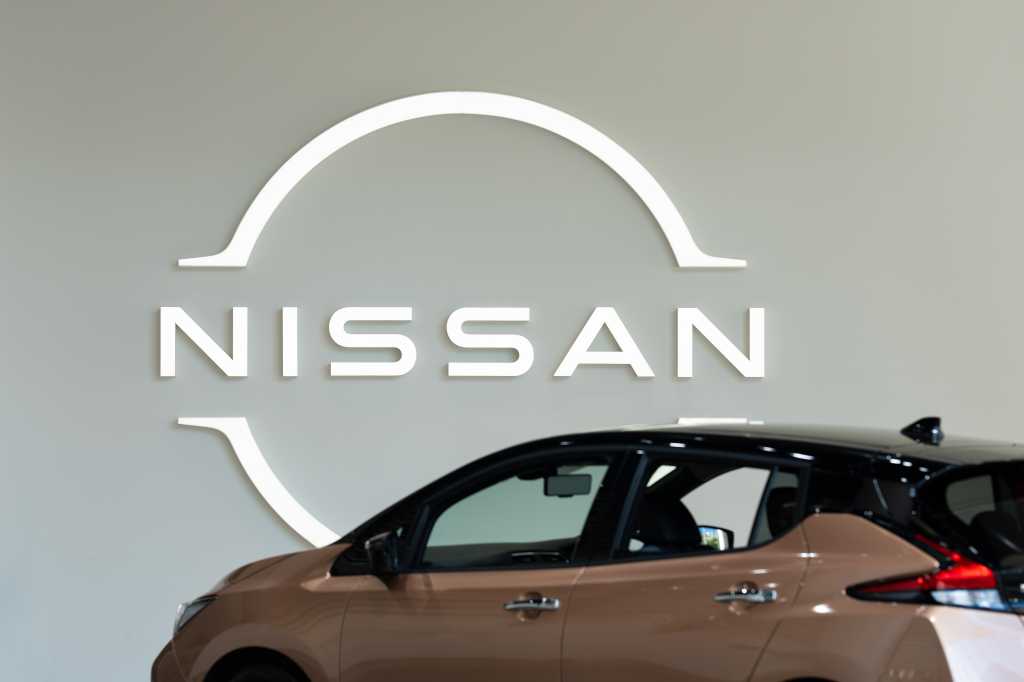 KANAGAWA, JAPAN - 20 January 2022：Nissan logo on the wall and Nissan car