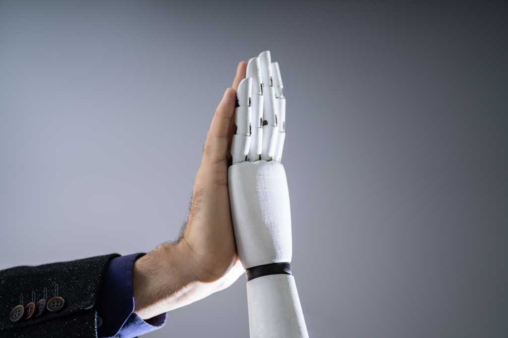 shutterstock 1612680487 Close-up Of Robot And Man Giving High Five Against Digital Background